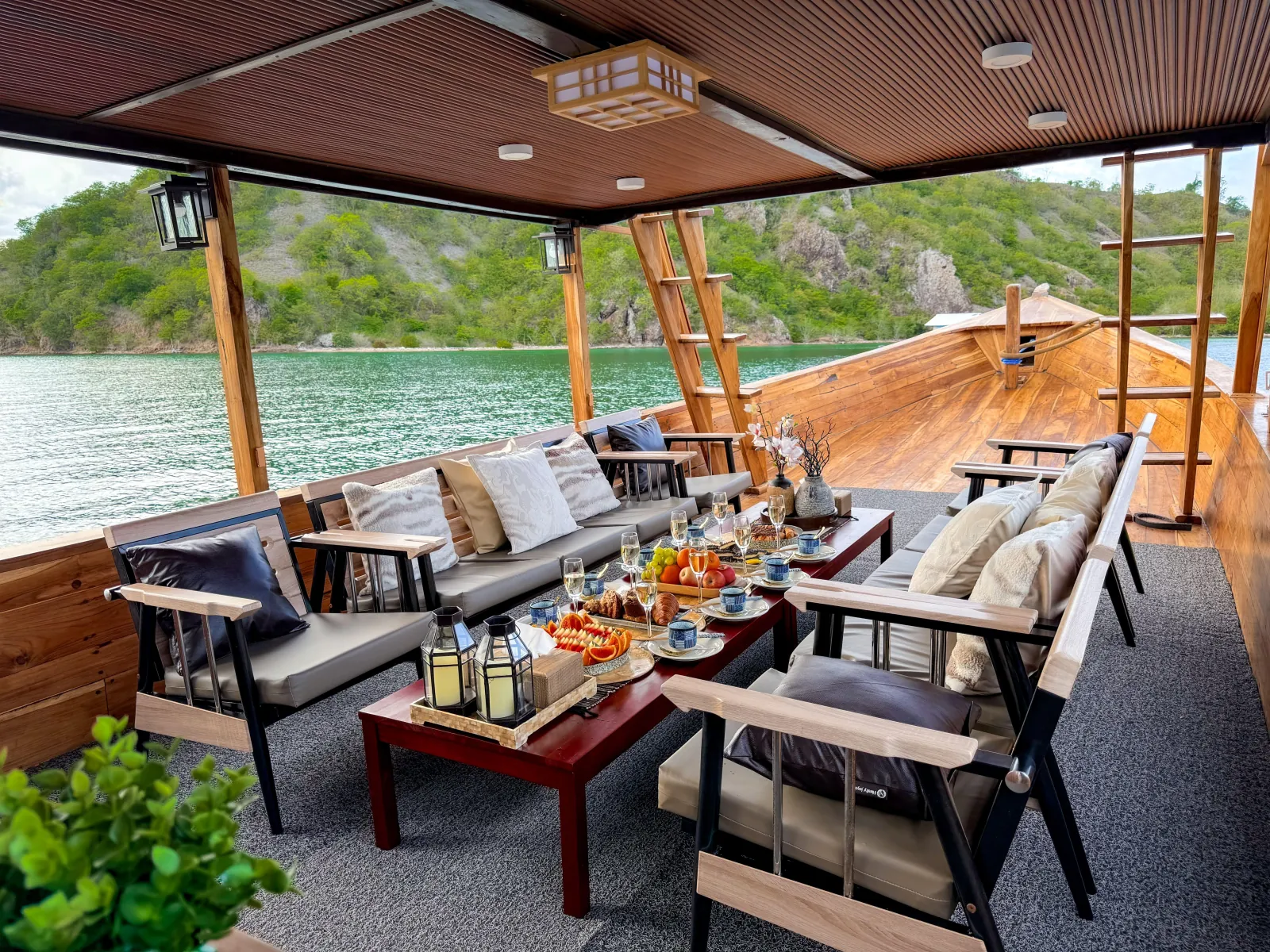 Open teak lounge deck with sofas and a low table set for the day