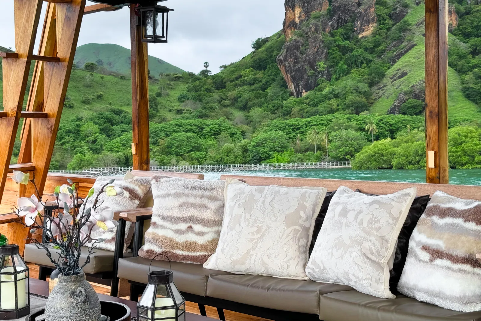 Cushioned deck seating looking out to green cliffs across the water