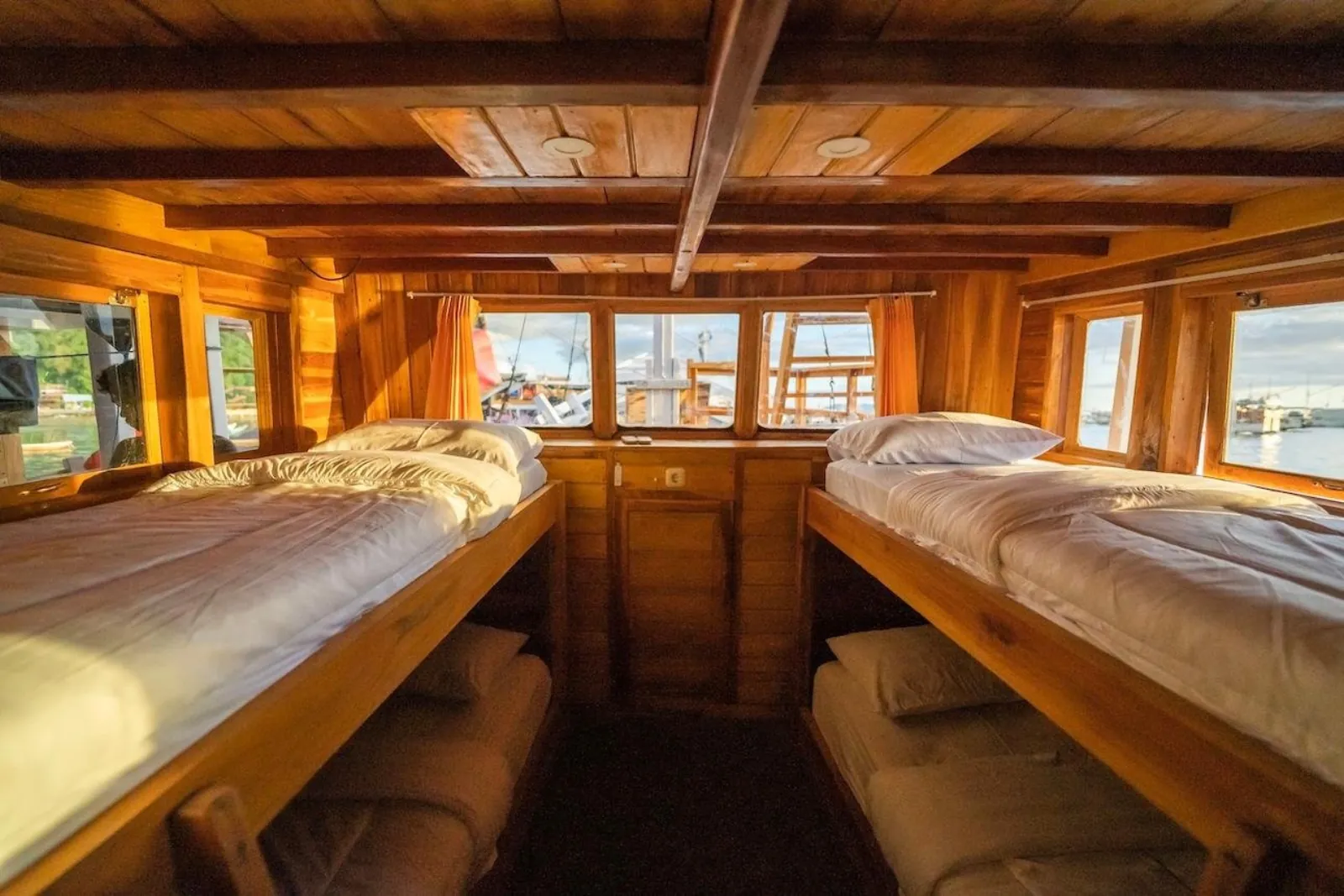 Timber shared cabin with facing single berths aboard the Komodo liveaboard