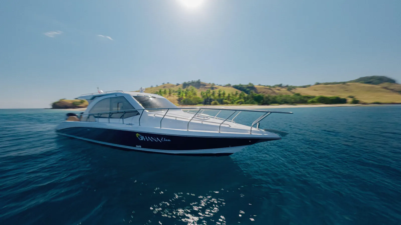 Dark-hulled speedboat under way past a headland in Komodo National Park
